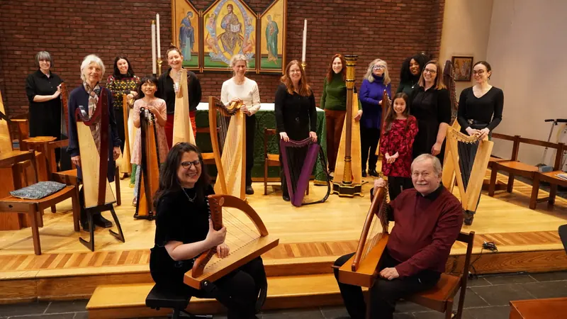 Harp students and their harps in concert in a church