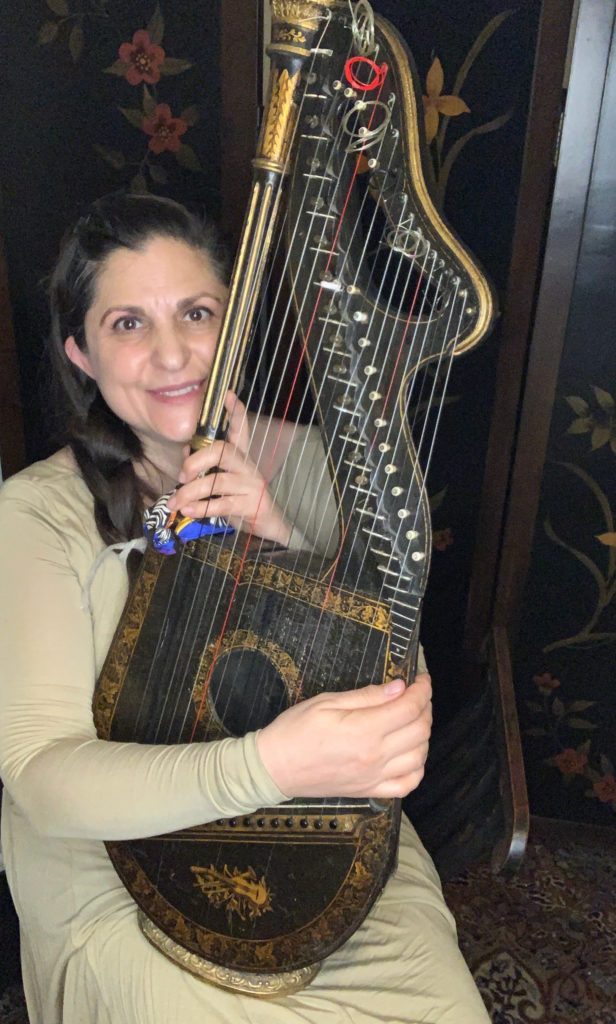 Mia Theodoratus holding her 1837 dital harp by Edward Light